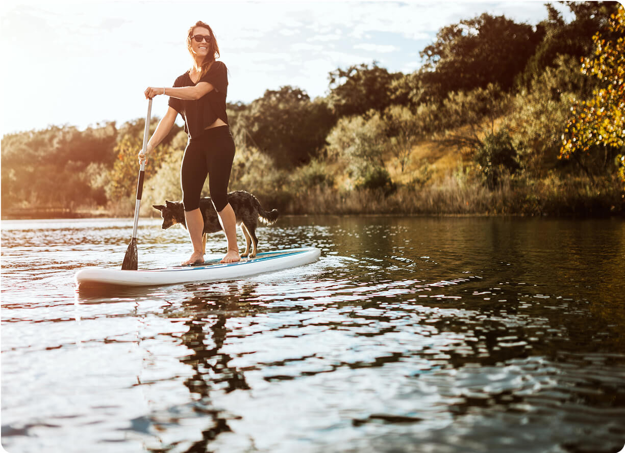 A woman paddle boarding in comfort because she had a HAE procedure