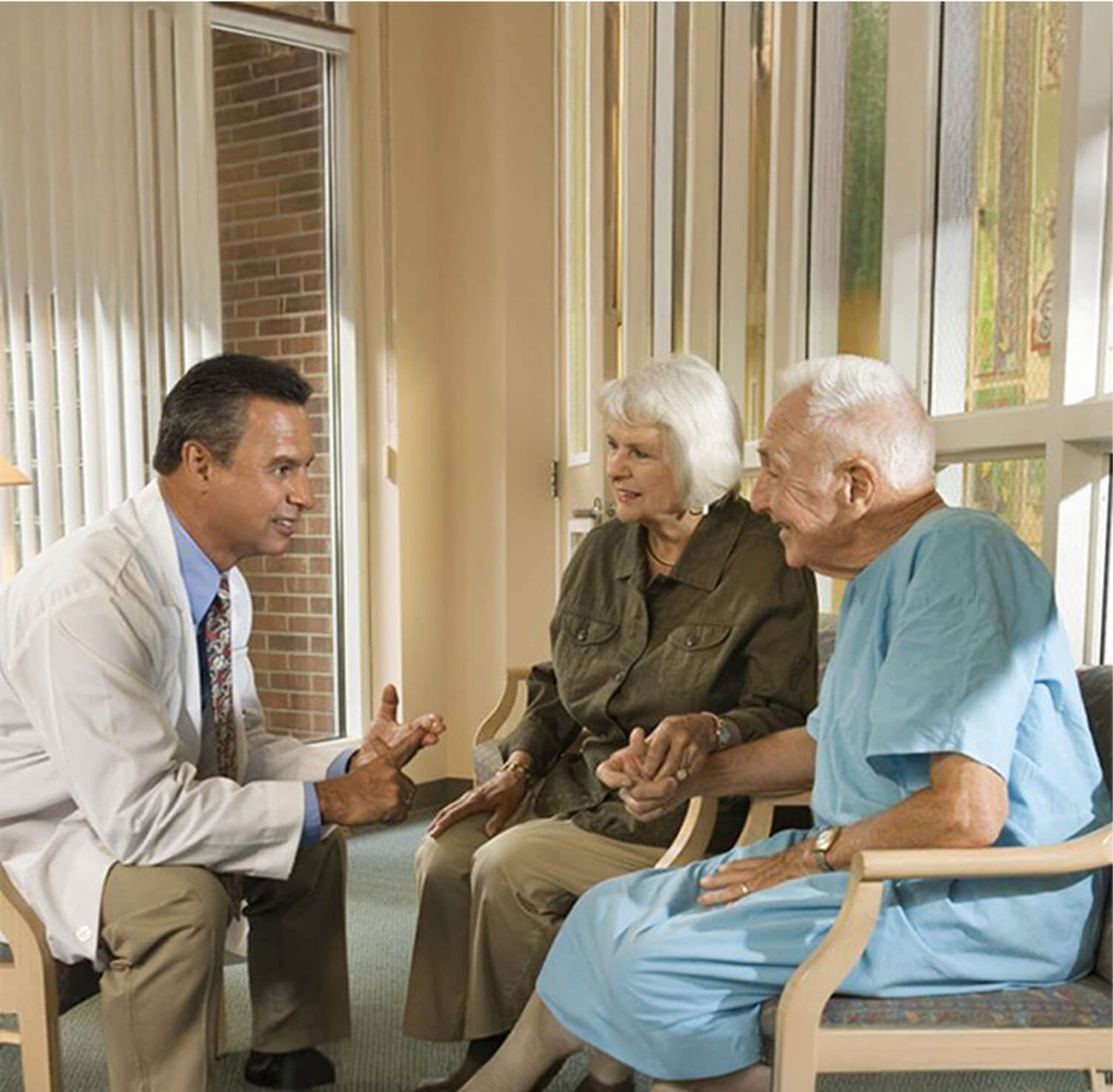 A couple and a healthcare worker discussing peripheral artery disease procedure